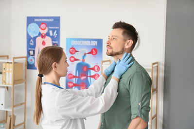 doctor examines man with thyroid concern