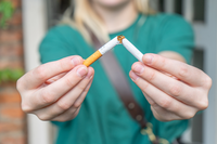 woman breaking cigarette in half