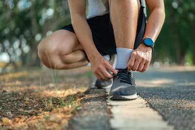 person tying shoes to exercise