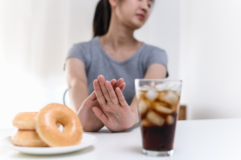 woman rejecting sugary food and drink