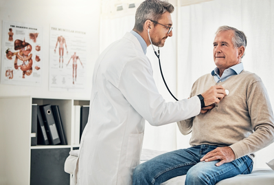 doctor checking man's heartbeat